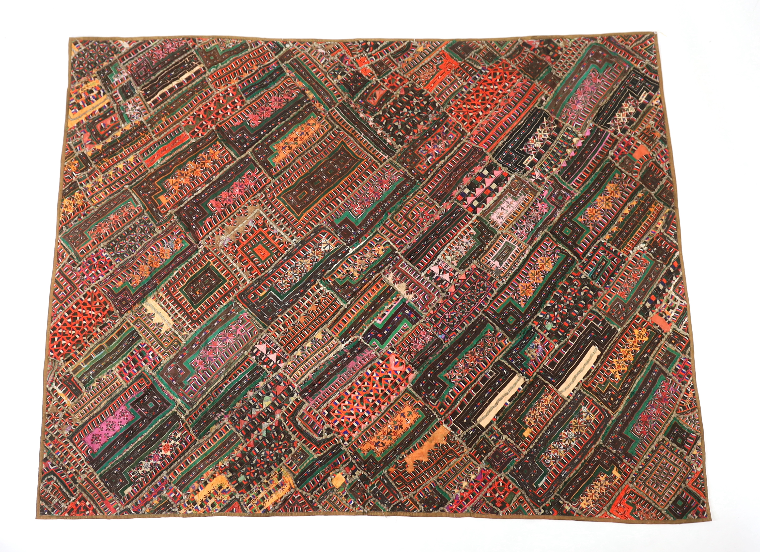 An interesting 20th century North Indian or Tibetan patchworked cover, worked in silk, wool and cotton embroidery in varying colours using thick bundles of threads to border / outline the patchwork, this has possibly bee
